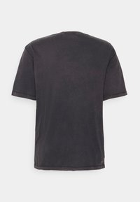 Mörkgrå kortärmad t-shirt med avslappnad passform, rund halsringning och fållade kanter. Mjuk textur med subtila färgvariationer.