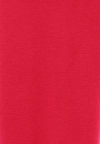 Czerwony kawałek tkaniny z dzianiny, gładka tekstura, jednolity kolor z minimalnymi wariacjami, bez wzorów ani widocznych akcentów.