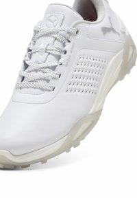 Adidaș alb, realizat din piele netedă, cu panouri laterale perforate, guler căptușit și şireturi texturate. Talpă din cauciuc cu aderență.