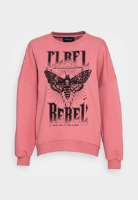 Sudadera rosa de corte holgado, con un gráfico negro de una polilla con una calavera y el texto "CLRLFL REBEL". Material de algodón suave.