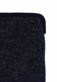 Black, textured wool fabric featuring a smooth black trim and a circular black button with a letter 'K' on the upper edge.