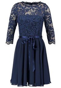 Mörkblå klänning med en spetstopp med blommönster, trekvartslånga ärmar och ett satinskärp med en rosett. Kjolen är utsvängd och fodrad.