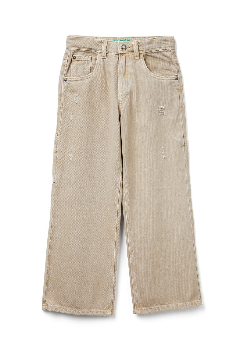 Béžové široké džíny s lehkým opotřebením, pěti kapsami, zapínáním na knoflík a poutky na opasek, položeny na bílé pozadí.