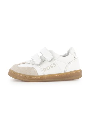Witte kindersneaker met beige suède neus, twee klittenbandsluitingen, bruine zool en merknaam "BOSS" aan de zijkant.