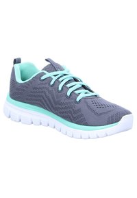 Chaussure de sport grise avec un dessus texturé, des accents turquoise et une semelle blanche légère. Présente un design à lacets et un matériau respirant.