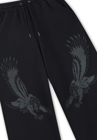 Zwarte sweatpants met een trekkoord in de taille en bedrukte agressieve arendontwerpen op beide benen.