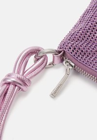 Paarse handtas met rits en een gestructureerde afwerking, voorzien van kleine sprankelende accenten, een metallic ritsring en een bijpassende schouderband.