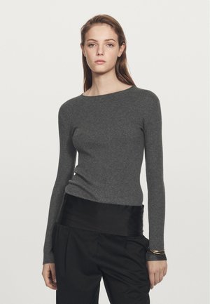 Grijze geribbelde lange mouw trui met een ronde halslijn, voorzien van een slim fit en een gestructureerde stof, gecombineerd met zwarte hoge taille broek.