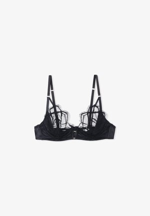 Bralette en dentelle noire avec panneaux transparents, bande sous-mammaire en satin et bretelles réglables. Présente une fermeture à deux crochets à l'avant. Détails en dentelle complexes.
