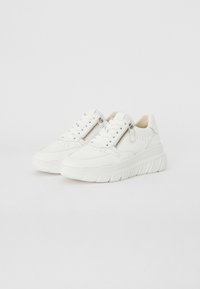 Baskets blanches avec une tige texturée, un bout arrondi, un col rembourré et une semelle épaisse. Dotées d'une fermeture éclair argentée sur le côté pour un enfilage facile.