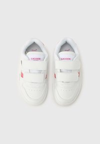 Λευκά sneakers Lacoste με ροζ λεπτομέρειες, διαθέτοντας λείο δερμάτινο επάνω μέρος, λουριά με αυτοκόλλητο και οπές για αναπνευσιμότητα.