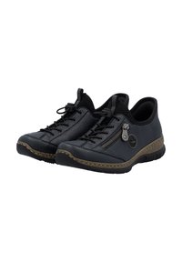 Chaussures en cuir noir avec surface texturée, bout rond, semelle marron contrastante, fermeture éclair décorative et détails tissés autour des bords de la semelle.