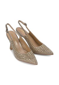 Tacchi slingback beige con punte affusolate, decorati con borchie argentate, caratterizzati da una tomaia testurizzata e un tacco a blocco di altezza media.