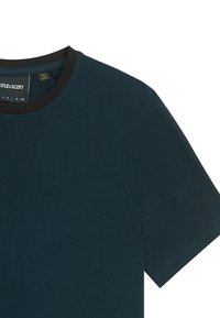 Mørk teal kortærmet T-shirt med en sort rund hals, lavet af blødt stof; har en etikette med brandnavn og størrelse.