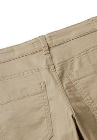 Béžové bavlněné kalhoty s hladkou strukturou, které mají dvě zadní kapsy a kontrastní prošívání podél švů.