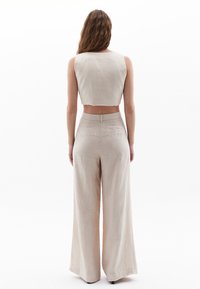 Beige linnen crop top en wijde broek, met een gladde textuur, minimale naden en een eenvoudig, strak ontwerp met een hoge taille.