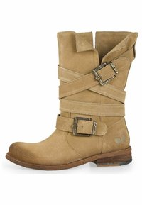Botas de tobillo de ante marrón con correas entrelazadas y detalles de hebillas metálicas. Punta redondeada y un tacón bajo apilado. Detalle de superficie texturizada.