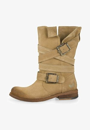 Smeđe antilop čizme do gležnjeva s ukrštenim trakama i metalnim kopčama. Okrogli vrh i niski potplat od složenog drva. Tekstura na površini.