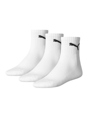 Calcetines tobilleros blancos con puño acanalado y logo negro de Puma en los lados. La tela parece suave y elástica. Paquete de tres pares.