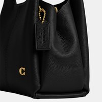 Czarna torebka z miękkiej skóry ziarnistej z złotym logo "C" i dopasowanym złotym łańcuszkiem z koralikami przymocowanym do skórzanego zawieszki.
