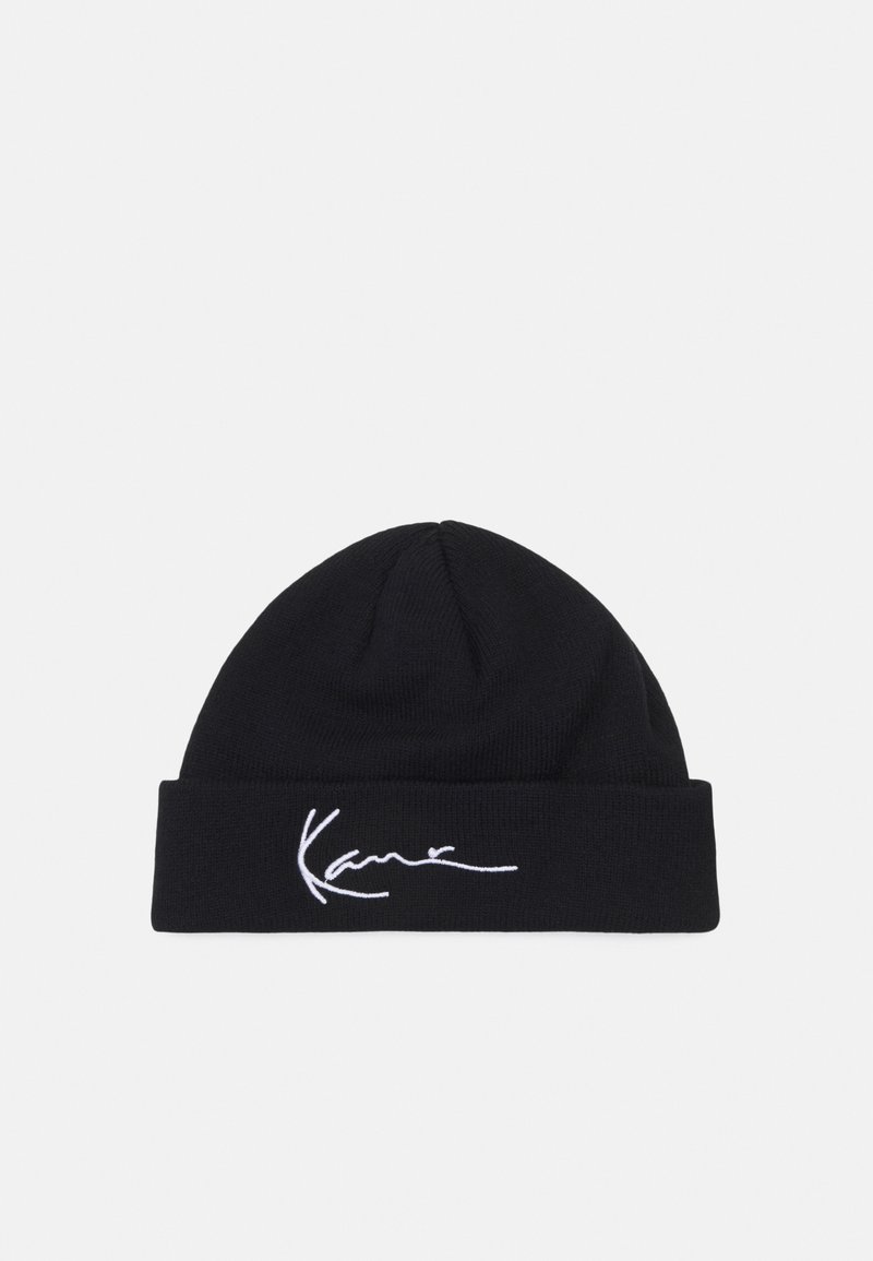 Black knitted beanie with a soft texture and a turned-up cuff. Features white embroidered signature detail on the front.