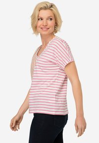 T-shirt a righe con strisce rosa e arancioni su uno sfondo bianco, con maniche corte e design a scollo a V. Materiale misto cotone.