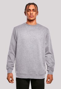 Grauer Pullover mit Rundhalsausschnitt, langen Ärmeln und gerippten Abschlüssen. Weicher Stoff, leicht meliertes Gewebe, lässige Passform, minimale Details.
