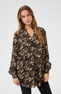 Blusa a maniche lunghe realizzata in tessuto leggero, con un motivo ondulato marrone, nero e crema, dotata di scollatura a V e polsini arricciati.