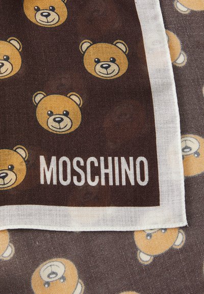 Material de culoare maro cu fețe de urs galbene repetate, detaliate cu negru. Text alb „MOSCHINO” apare la marginea de jos. Textură ușoară.