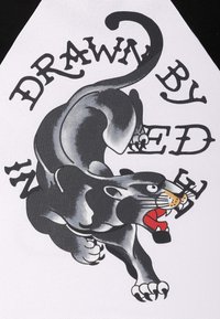 Czarny i szary wzór pantery z czerwonymi akcentami oraz wyrazistym napisem na białym tle, charakteryzujący się gładką teksturą i dynamiczną pozą.