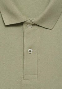 Olivenfarbendes Poloshirt aus strukturiertem Stoff, mit einer Knopfleiste mit drei Knöpfen und einem klassischen Kragen. Leichtes, atmungsaktives Material.