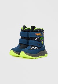 Bottes de sport bleues avec des accents noirs, deux sangles Velcro, doublure intérieure verte et une semelle texturée. Caractéristiques des motifs Hot Wheels et des détails éclatants.