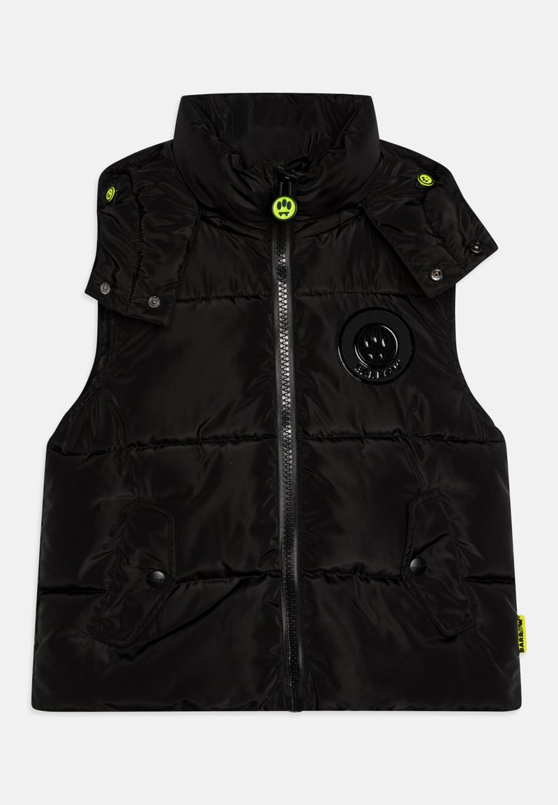 Chaleco negro acolchado hecho de material brillante, con un alto cuello, botones de presión verdes, cremallera frontal y un logotipo redondo en el lado izquierdo.