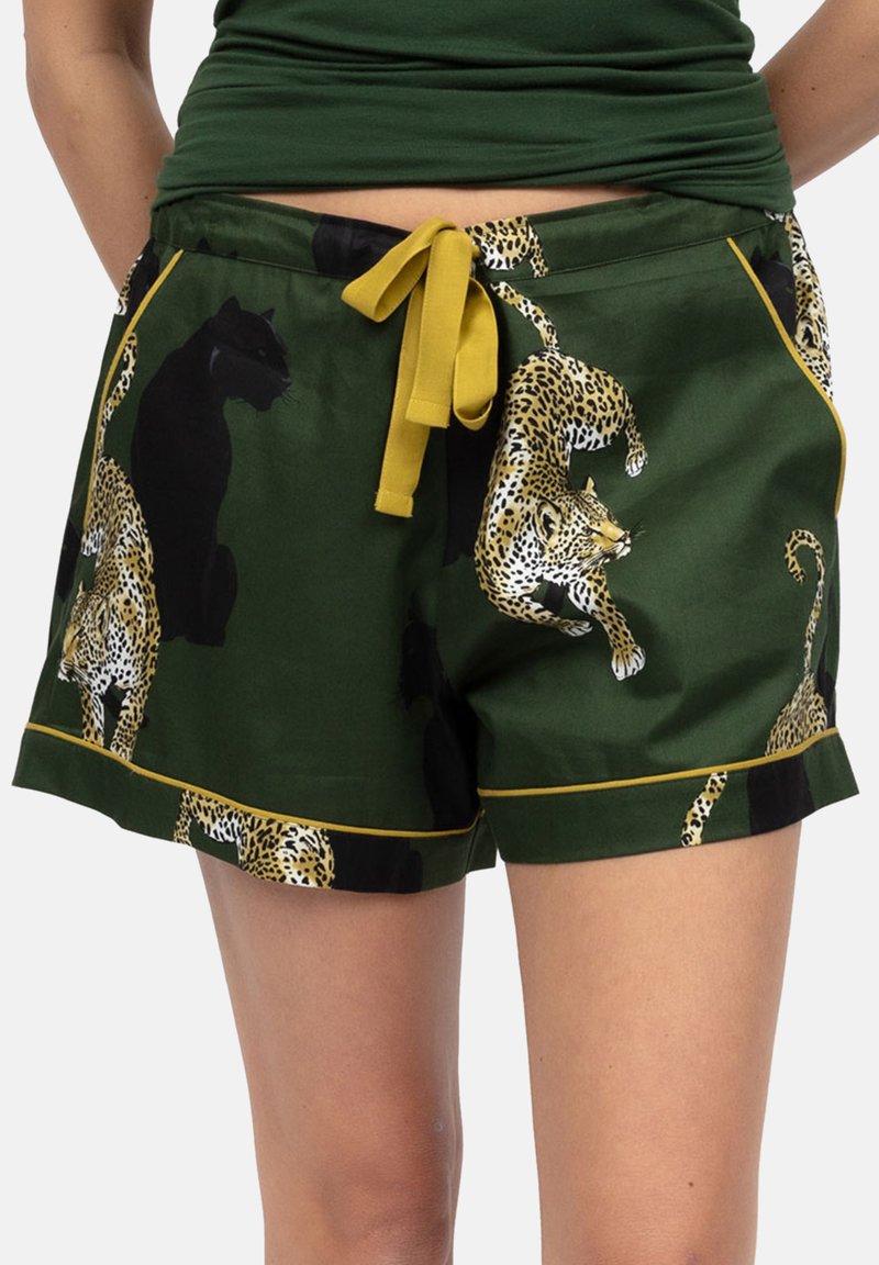 Groene shorts met gele bies en een trekkoord, met geprinte jaguars en zwarte panters op de onderlichaam en benen van een persoon.