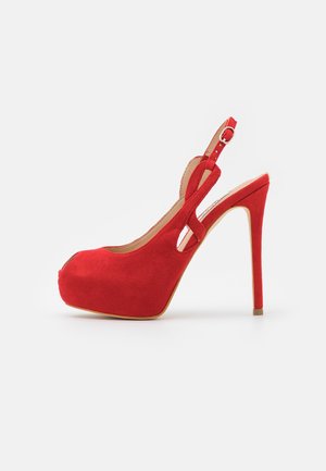 Roter Veloursleder-Pumps mit hohem Absatz und Plateau, offenem Zehenbereich und verstellbarem Knöchelriemen, seitlich dargestellt auf weißem Hintergrund.