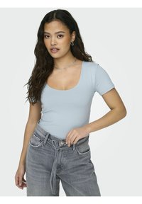 Lyseblå kortermet body med scoop-hals, kombinert med høyt liv, lysegrå bukser med snor i midjen.