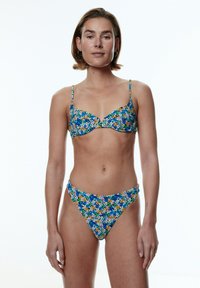 Bloemige bikini-set met een blauwe achtergrond, voorzien van kleurrijke bloemen. De top heeft gevormde cups en verstelbare banden; de onderkant is van het low-rise type.