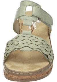 Light green leather sandal with woven design, adjustable strap with a circular accent, and a tan cushioned footbed.