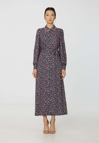 Robe longue bleu marine avec motif floral rose, col à revers, manches longues et ceinture assortie à la taille. Tissu lisse, silhouette longueur cheville.