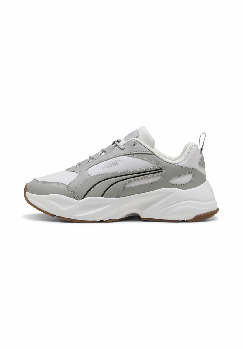Scarpa atletica grigio e bianca con tomaia in pelle testurizzata, suola in gomma e linee di accento. Presenta un colletto imbottito e dettagli riflettenti.