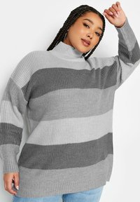 Grau und hellgrau gestreifter Strickpullover mit hohem Hals, langen Ärmeln und seitlichen Schlitzen, aus einem strukturierten Garn gefertigt. Lässige Passform.