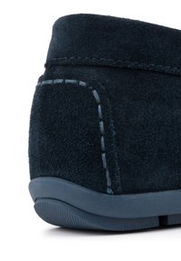 Ciemnoniebieskie zamszowe buty z zaokrąglonym obcasem, z kontrastującymi jasnoniebieskimi szwami i teksturowaną gumową podeszwą. Gładkie wykończenie całości.