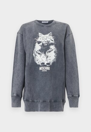 Γκρι φούτερ Moschino με λευκό γραφικό από μια αφράτη γάτα που φορά γυαλιά και παπιγιόν, με το κείμενο «Moschino Jeans» από κάτω.