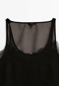 Top nero senza maniche con materiale trasparente, spalline sottili e dettagli in pizzo lungo il collo e l'orlo. Design semplice e rilassato.