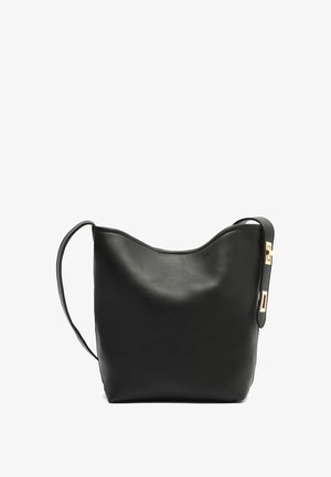 Bolso de cuero negro con forma superior curva, base plana y una larga correa con acentos de hardware dorado. Textura suave, diseño minimalista.