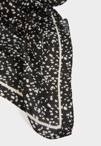 Sciarpa a motivi bianco e nero con una texture sgualcita, caratterizzata da macchie bianche sparse e un bordo bianco solido lungo il margine.