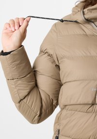 Beżowa kurtka puchowa z pikowanym wzorem, z kapturem, elastycznymi mankietami i sznurkiem w kołnierzu do regulacji dopasowania.