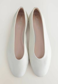 Valkoiset ballerina-kengät, jotka on valmistettu sileästä nahasta, pyöreillä varpailla ja matalilla sivuilla. Sisäpuolella on kevyt pehmustus, joka on suunniteltu mukavuutta varten.