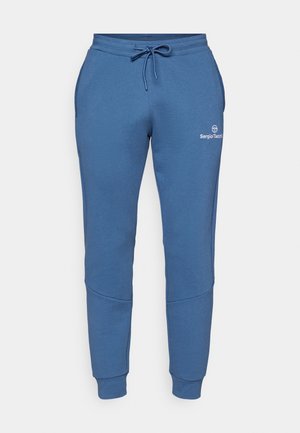 Blaue Sweatpants aus weichem Material mit einem elastischen Bund und Kordelzug, seitlichen Taschen und einem Logo am Oberschenkel.