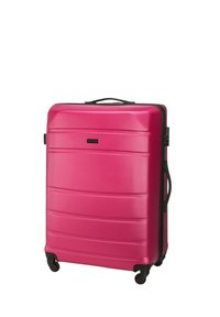 Valise rigide de couleur rose vif avec surface texturée, fermeture éclair noire et une poignée supérieure. Équipée de quatre roues pour une mobilité facile.